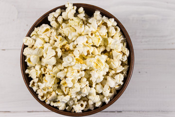 Obraz na płótnie Canvas Bowl with popcorn on wooden table