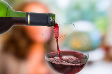 Red wine pouring into a wine glass - celebration concept