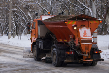 To snowblower clears the road and sand
