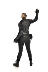 Fototapeta premium full length portrait of female soldier wearing black tactical armour facing away from camera, isolated on white studio background.