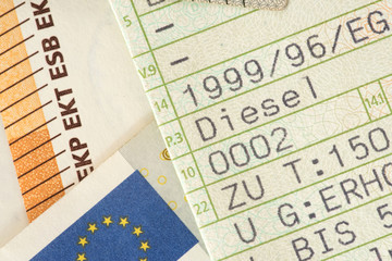 Ein Fahrzeugschein für ein Diesel Auto und Euro Geldscheine