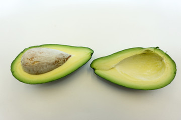 Avocado cut in half with bone isolated on white background Clipping Path .