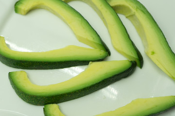 Pieces of avocado isolated on white .