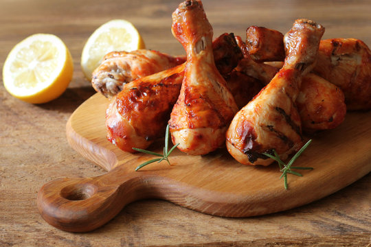 Grilled chicken legs on cutting board.Rustic dinner background