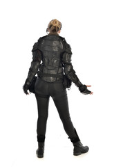 full length portrait of female  soldier wearing black  tactical armour  facing away from camera, isolated on white studio background.