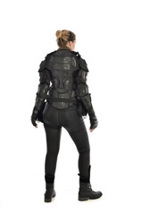 Fototapeta premium full length portrait of female soldier wearing black tactical armour facing away from camera, isolated on white studio background.