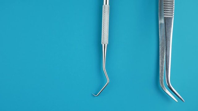 Professional Dentist tools in dental office: dentist mirror, forceps curved, explorer curved, dental explorer angular and explorer curved with chip, right. Dental Hygiene and Health conceptual image
