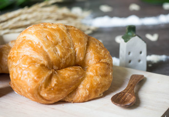 One croissant on wood tray, selective focus