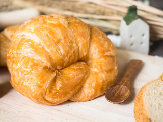 One croissant on wood tray, selective focus