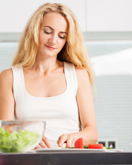 Young woman preparing vegetable salad