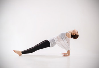 Young woman doing yoga exercise on the floor.