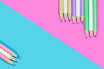 Pencils of colorful on pink and blue background.