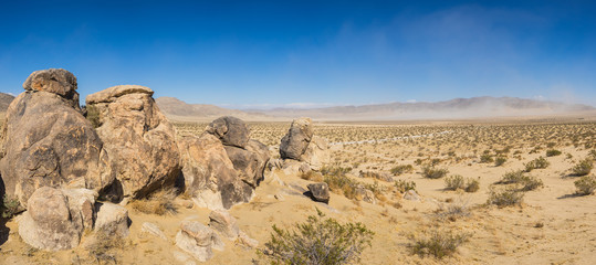 Line of large stone boulders leading into the sand of southern California's Mojave Desert.
