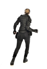 full length portrait of female  soldier wearing black  tactical armour  facing away from camera, isolated on white studio background.