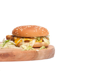 Burger,fries and fried chicken on wooden chopping board isolated over white background.