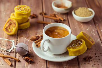 Indian tea masala with spices in white cup, Indian food on wooden table