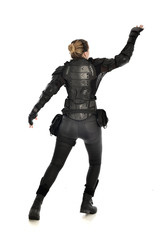 Fototapeta premium full length portrait of female soldier wearing black tactical armour facing away from camera, isolated on white studio background.