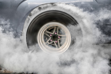 Drag racing car burns rubber off its tires in preparation for the race