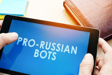 Man holding tablet with words pro-russian bots. Russian internet propaganda concept.