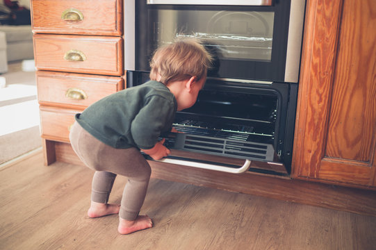 Little toddler exploring oven