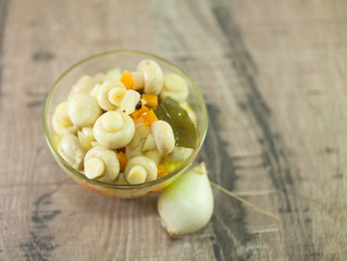 pickled mushrooms with carrot on wooden table