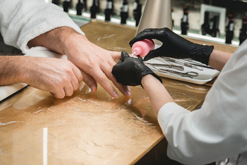 mans manicure master during nail treatment