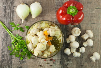 pickled mushrooms with green dill on wooden plate
