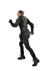 full length portrait of female  soldier wearing black  tactical armour  facing away from camera, isolated on white studio background.