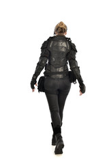full length portrait of female  soldier wearing black  tactical armour  facing away from camera, isolated on white studio background.