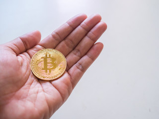 Bitcoin in woman's hand on white background, cryptocurrency investment concept.