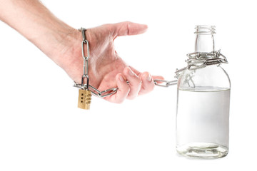 a bottle of alcohol in hand with chain and lock. the concept of alcohol dependence