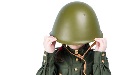 little girl in military uniform, hid her head in a hard hat, place for inscription, isolated on white