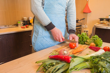 Man hands cutting vegetables on kitchen blackboard. Healthy food. Male preparing vegetables