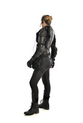 Fototapeta premium full length portrait of female soldier wearing black tactical armour facing away from camera, isolated on white studio background.