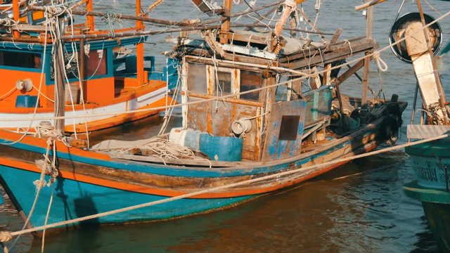 Old wooden half-ruined and wrecked ship is moored on a fishing dock