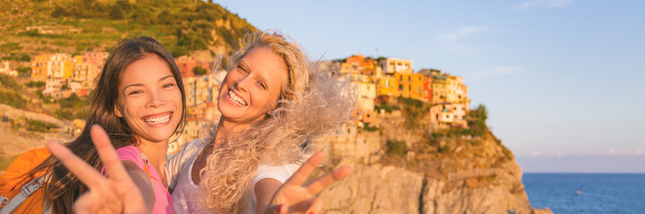 Fototapeta premium Travel tourists girls friends having fun hiking in Cinque Terre , Italy summer vacation. Happy girlfriends backpacking through Europe laughing banner panorama.
