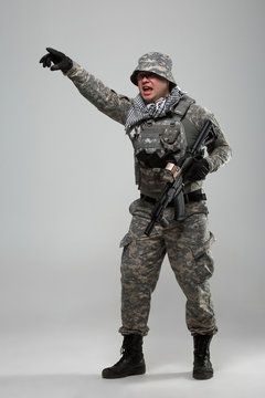 Full-length picture of military man in helmet with hand pointing