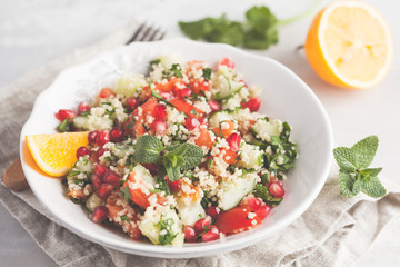 Tabbouleh salad with tomato, cucumber, couscous, mint and pomegranate. Vegan Healthy Food Concept. Traditional middle eastern or arab dish.
