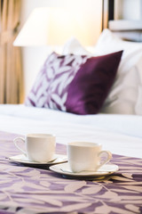 White coffee cup on bed