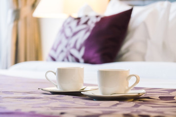 White coffee cup on bed