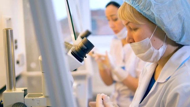Two female scientists are working in a laboratory with medical equipment.