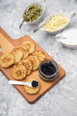 Schwarzer Kaviar auf Perlmuttlöffel mit Pfannkuchen, Eier Hack, Saure Sahne und Relish 