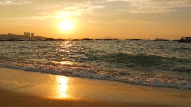 Very beautiful sunset on the seashore. Sandy beach and waves that beat on beach