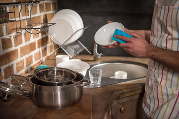 cropped image of man washing dishes at kitchen