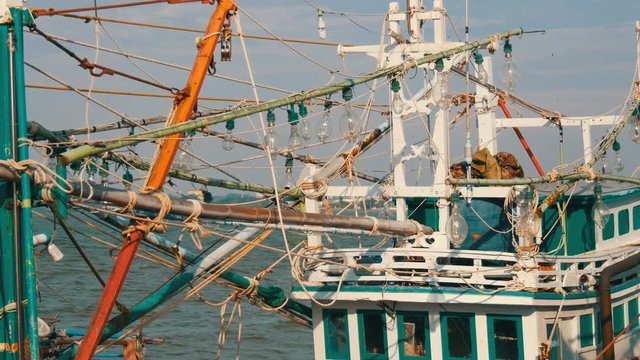 Old wooden half-ruined and wrecked vessel for catching squid is moored on a fishing dock