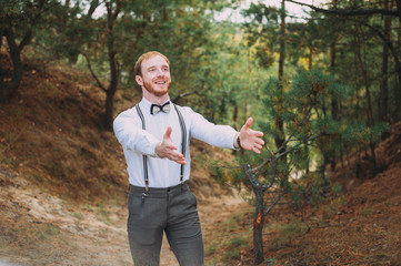 Hipster. Stylish groom with beard posing outdoors