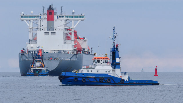 
MARITIME TRANSPORT - LNG tanker flows into sea secured by tugs
