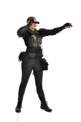 full length portrait of female  soldier wearing black  tactical armour  holding  a pair of binoculars, isolated on white studio background.