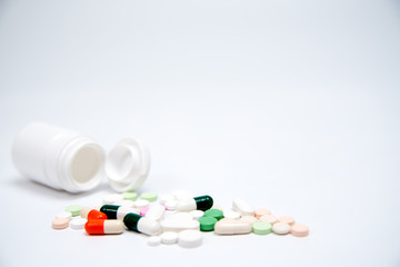 Pills and white bottle on white background.  With copy space in background. Used for health or medical manufacturing industry concept.