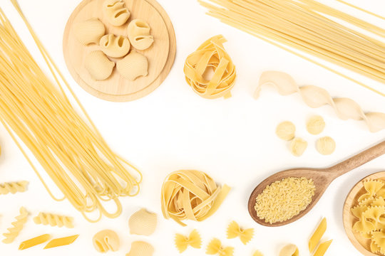 Overhead photo of different types of pasta on white with copy space